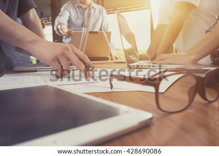 Business man hand pointing at business document during discussion at meeting.vintage tone
