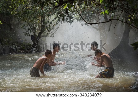 Sakon Nakhon Province, Thailand - November 8: Four boys play in the water on November 8, 2015, in Sakon Nakhon Province, Thailand.