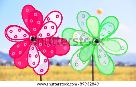 colorful pinwheels with sea of flowers as background