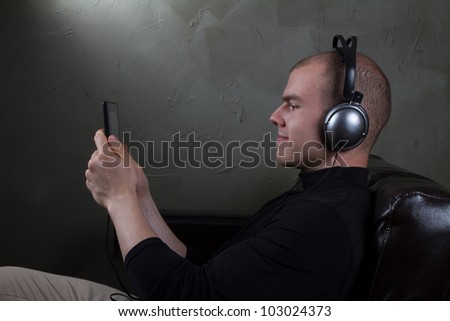 young man well dressed listens to music on a tablet