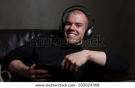 young man well dressed listens to music on a tablet