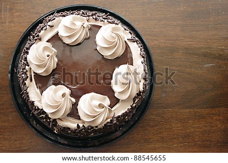 Chocolate cake with mocha icing swirls on an antique table