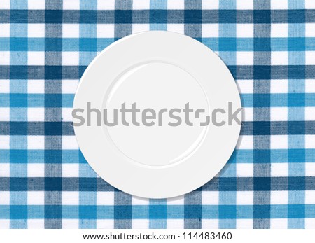 White plate on blue and white tablecloth background