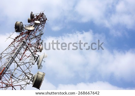 Telecommunication mast with microwave link and TV transmitter antennas on blue sky background