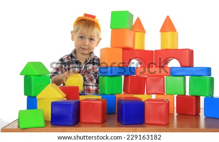 boy builds a house out of blocks