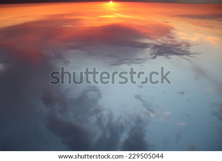 Inverted sunset over the sea as the concept of reflection of the universe