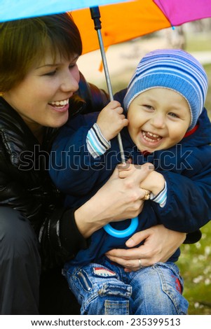 mom with a little boy in the rain under an umbrella