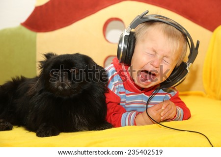 funny kid with a dog listening to music in headphones