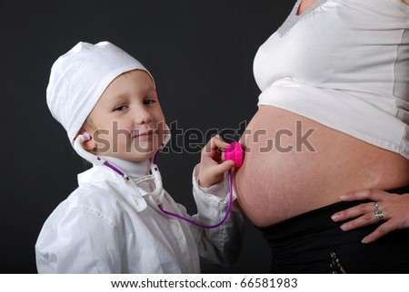 boy dressed as doctor and a pregnant mother