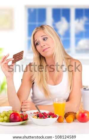 Attractive young woman having healthy or unhealthy decision of breakfast