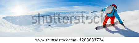 Snowboarder skiing downhill, panoramic format. Winter sports and leasure activities