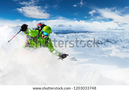 Alpine freeride skier skiing downhill with powder snow explosion. Winter sports and leasure activities