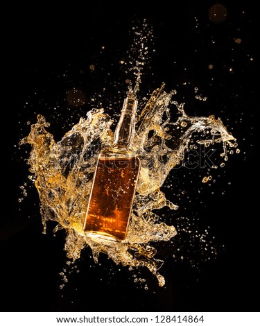 Concept of liquor splashing around bottle, isolated on black background
