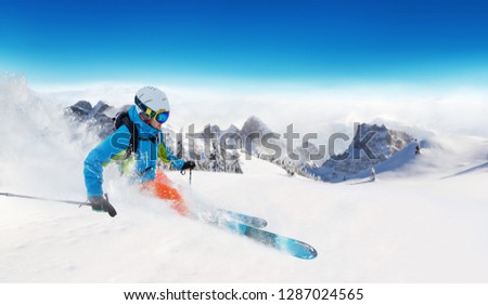 Young man skiing on piste. Winter sport and recreation in alpen mountain.