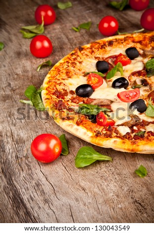 Delicious italian pizza served on wooden table Delicious italian pizza served on wooden table