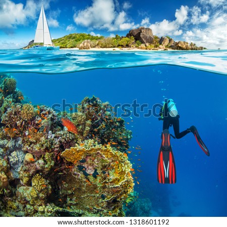Young woman snorkling next to tropical island. Anchoring catamaran on background