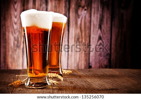 Glasses of beer on wooden table
