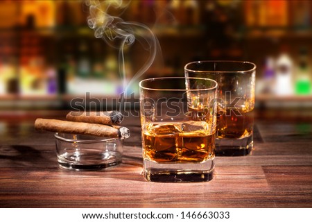 Whiskey drinks with smoking cigars