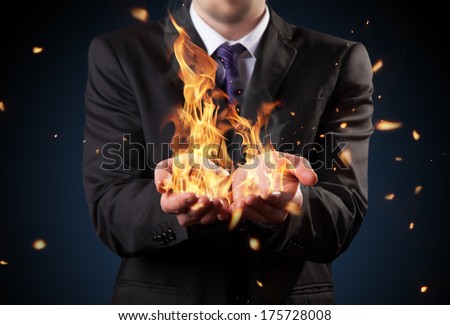 Businessman with fire in hands. Concept of threats and manager responsibility