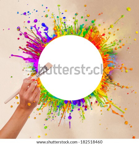 Colored paint splashes in round shape with free space for text in center. Woman hand holding paintbrush. Paper texture around