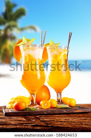 Fresh summer orange drinks, blur beach on background