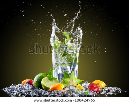Studio shot of fresh mojito drink with ice cubes and splash on black background