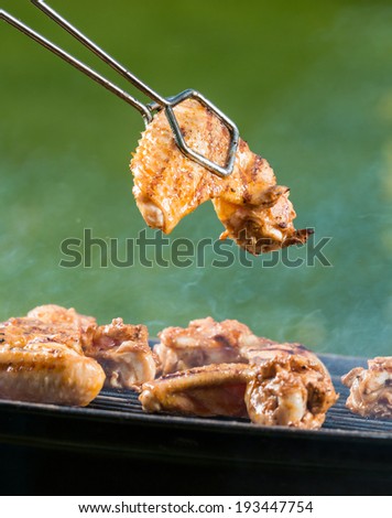 Chicken wings on barbecue grill with fire