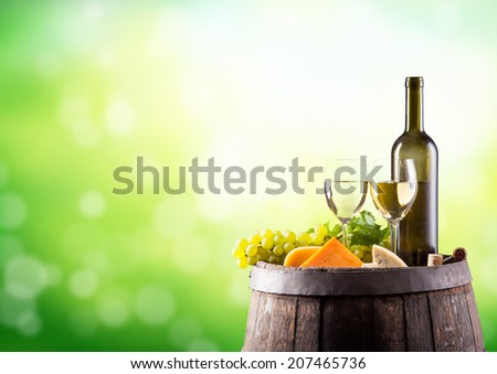 Wine still life on wooden keg with blur green abstract background