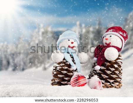 Winter holiday happy snow men with blur landscape on background. Concept love and togetherness