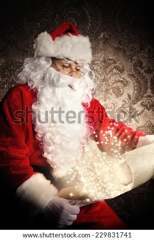 Christmas concept with Santa Claus in costume holding wish list. Dark pattern as background
