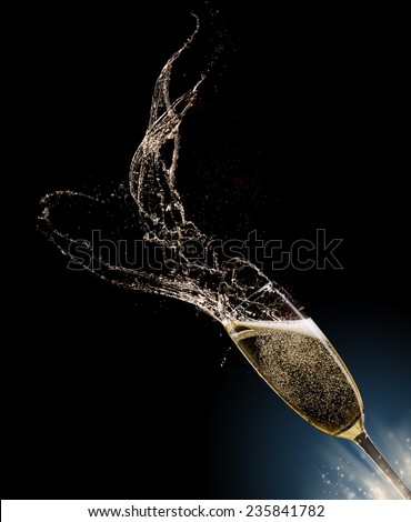 Glass of champagne with splash, isolated on black background