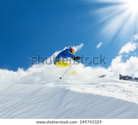 Male skier on downhill free-ride with sun and mountain view
