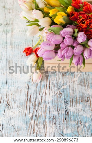 Bouquet of colored tulips in wooden box.