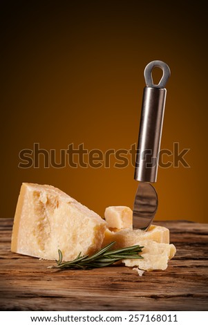 Parmesan cheese served on wood with knife