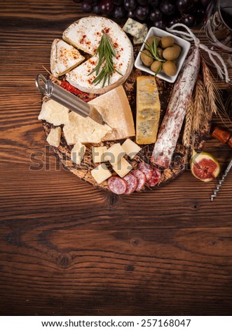 Cheese and salami arrangement served on cutting board. Shot from aerial view