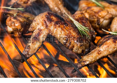 Chicken wings on barbecue grill with fire