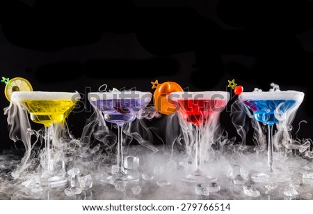 Martini drinks with dry ice smoke effect, served on bar counter with black background
