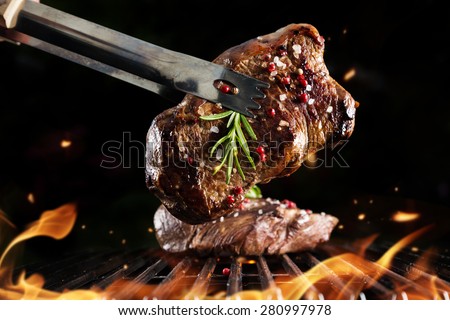 Beef steak on grill, isolated on black background