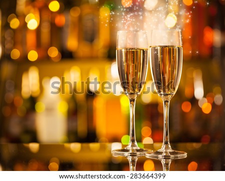 Celebration theme with two glasses of champagne. Blur bottles on background