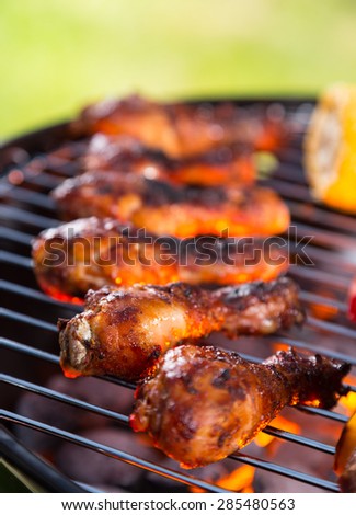 Chicken legs on barbecue grill with fire
