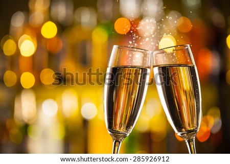 Celebration theme with two glasses of champagne. Blur bottles on background