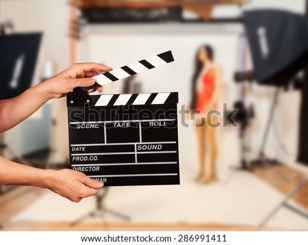 Man hands holding film clapper. Blur film studio on background