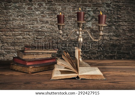 Old vintage books with candles in candlestick