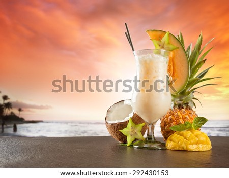 Exotic summer drink served on stone. Blur beach as background