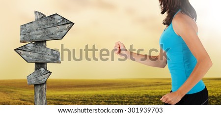 Close-up of woman runner with blank sign post. Detail on body and arms. Concept of body training and healthy lifestyle.