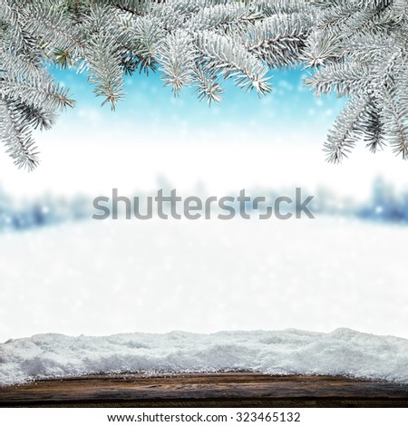 Winter background with pile of snow and blur landscape. Empty wooden planks on foreground. Copyspace for text