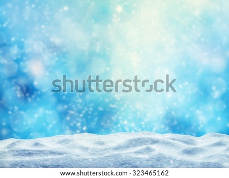 Winter background with pile of snow and blur abstract lights. Copyspace for text