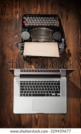 Old typewriter with laptop placed on wooden table. Concept of technology progress
