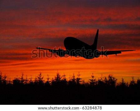 Big jet airplane silhouette flying on horizon in sunset