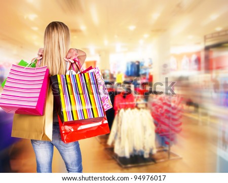 Blond woman with shopping bags in shopping center